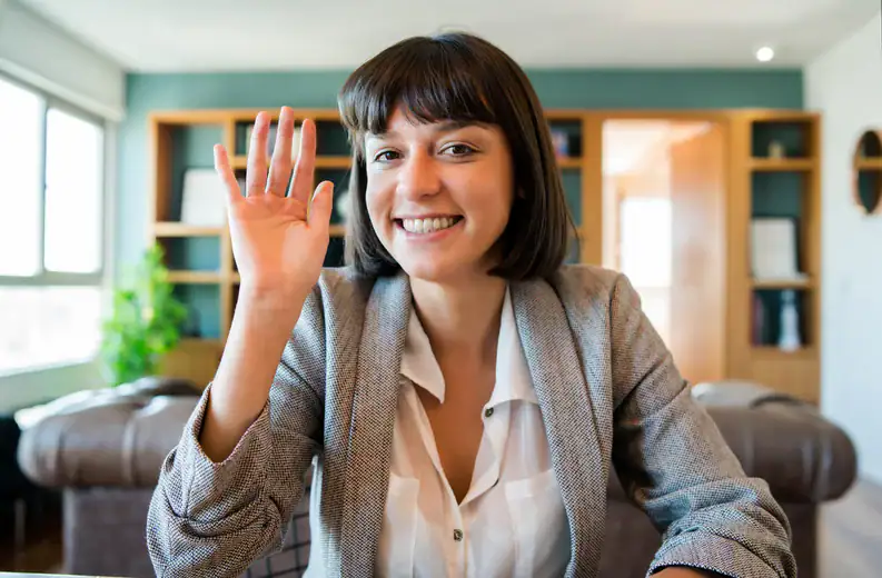 Woman smiling and waving, demonstrating confidence and calmness in a therapy setting.